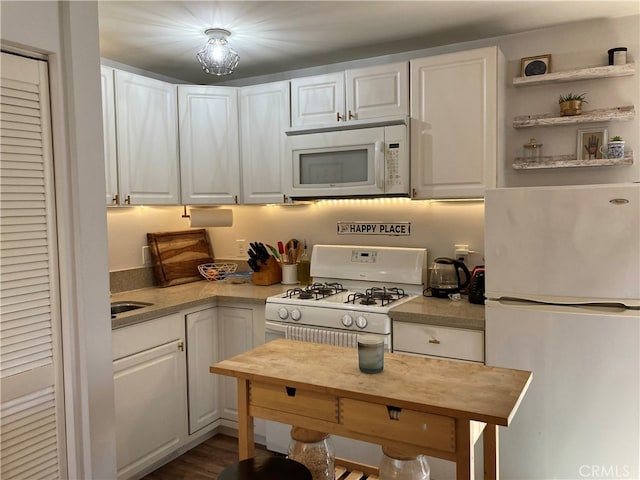 kitchen featuring wood-type flooring, white appliances, and white cabinets