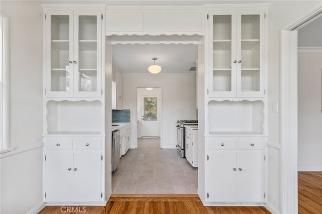 kitchen with white cabinetry, light hardwood / wood-style floors, appliances with stainless steel finishes, and decorative light fixtures