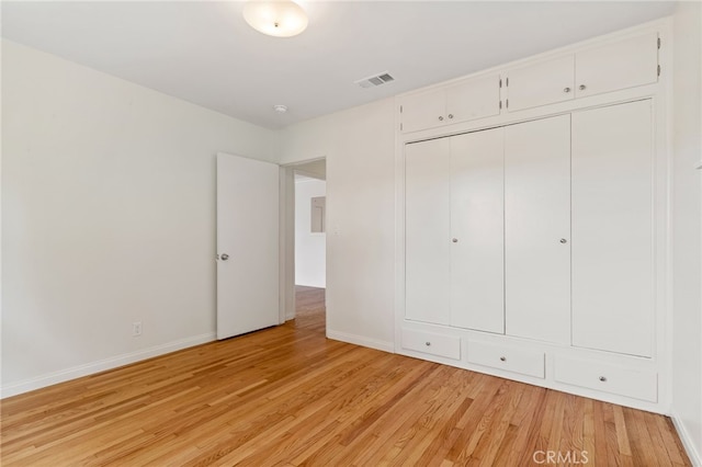 unfurnished bedroom with light wood-type flooring and a closet