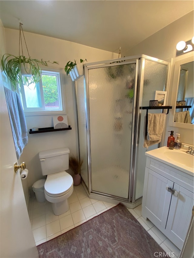 bathroom featuring vanity, tile patterned flooring, toilet, and an enclosed shower