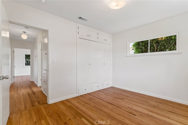 unfurnished bedroom with a closet and light hardwood / wood-style floors