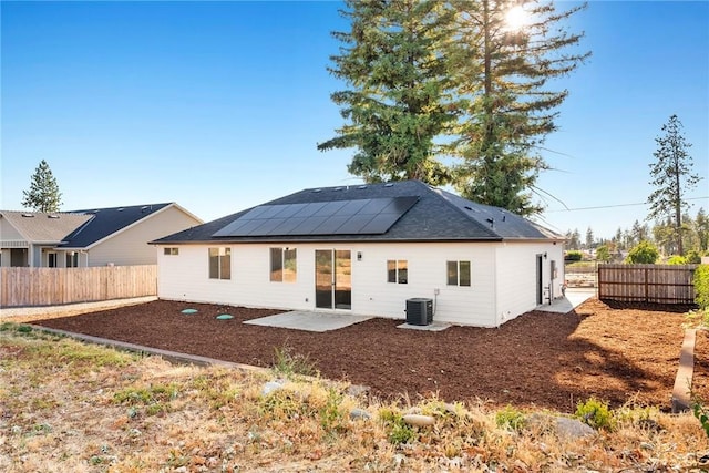 rear view of house featuring solar panels, a patio, and central AC