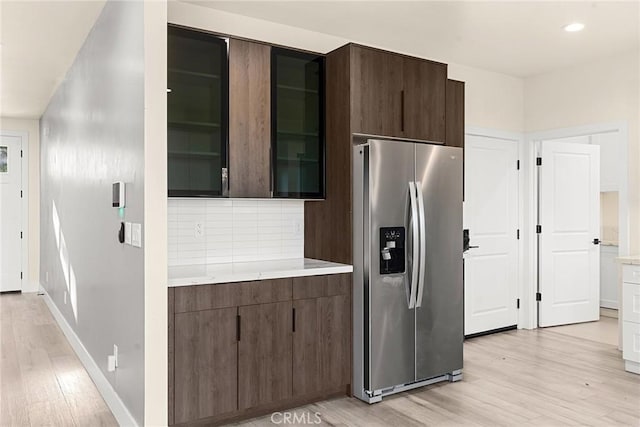 kitchen with dark brown cabinetry, stainless steel refrigerator with ice dispenser, and light hardwood / wood-style flooring