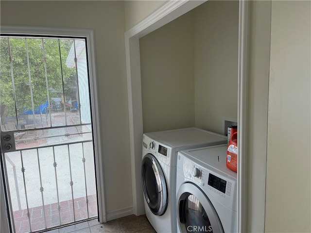 laundry area with light tile patterned floors and washer and dryer