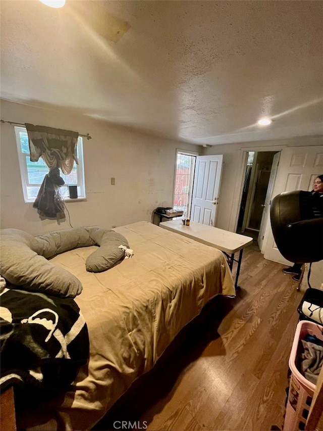 bedroom with a textured ceiling and hardwood / wood-style floors