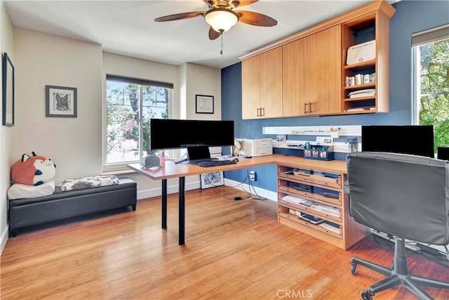 office area featuring ceiling fan, baseboards, a healthy amount of sunlight, and light wood-style flooring