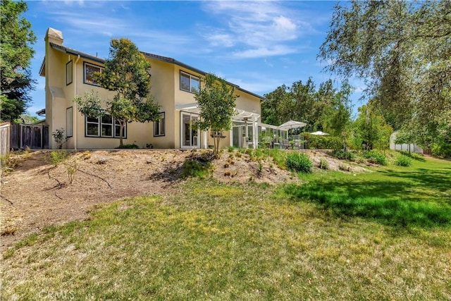 view of front of property featuring stucco siding, a front lawn, and fence