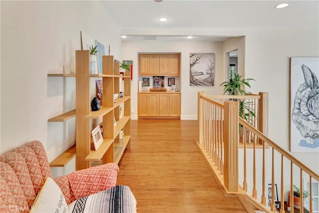 hall featuring recessed lighting, light wood-type flooring, an upstairs landing, and baseboards