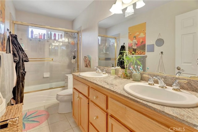 bathroom featuring tile patterned floors, enclosed tub / shower combo, toilet, and a sink