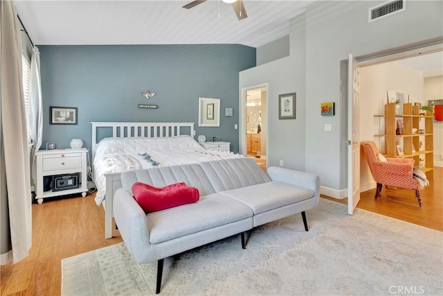 bedroom with a ceiling fan, wood finished floors, visible vents, and baseboards