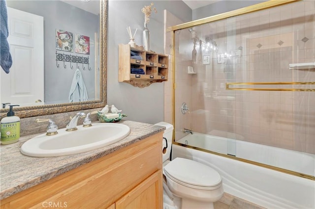 full bathroom featuring toilet, vanity, and bath / shower combo with glass door