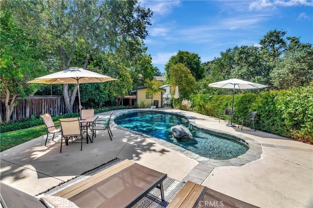 view of swimming pool featuring an outbuilding, a fenced in pool, a patio, and fence