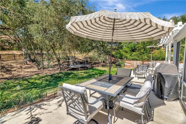 view of patio featuring outdoor dining space, a grill, a pergola, and a fenced backyard