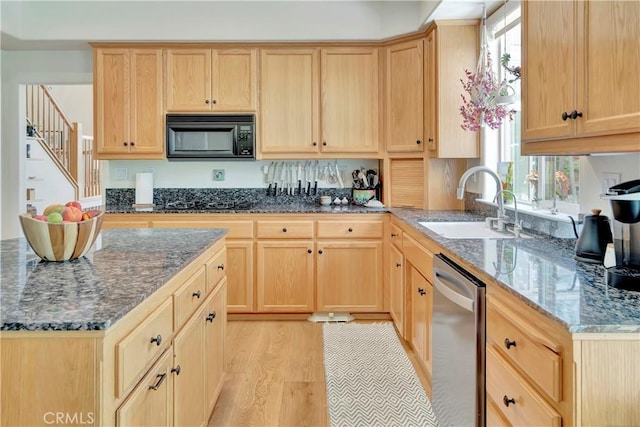 kitchen featuring a sink, dark stone counters, black appliances, and light brown cabinets