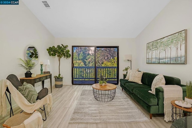 living room featuring light wood-type flooring and high vaulted ceiling