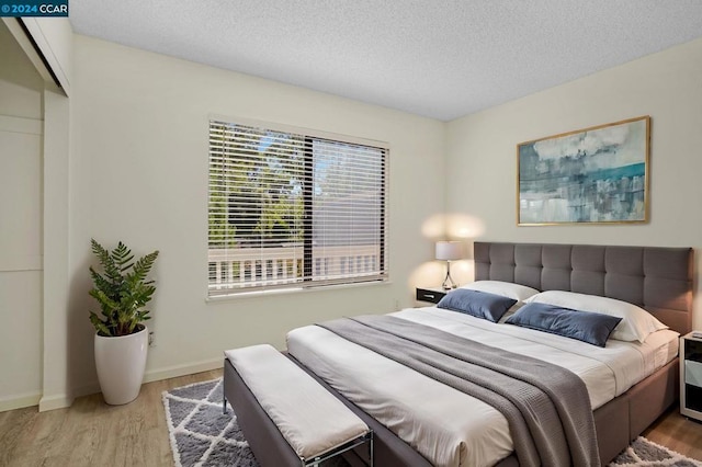 bedroom with wood-type flooring and a textured ceiling