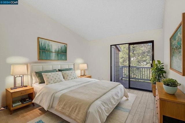 bedroom featuring access to exterior, vaulted ceiling, and light hardwood / wood-style flooring