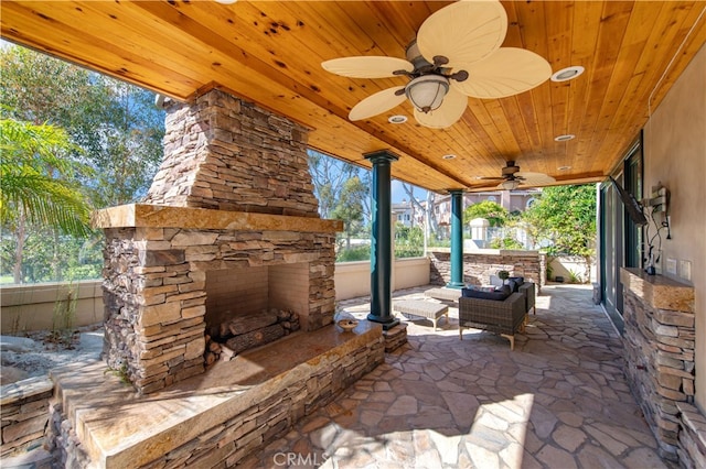 view of patio / terrace with ceiling fan and an outdoor stone fireplace