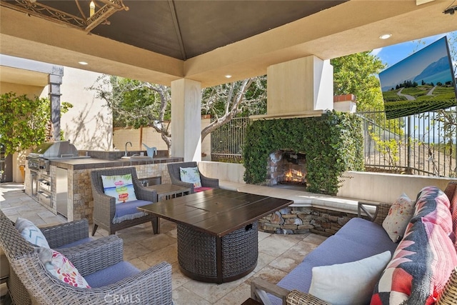 view of patio with an outdoor living space with a fireplace, area for grilling, an outdoor kitchen, and a gazebo