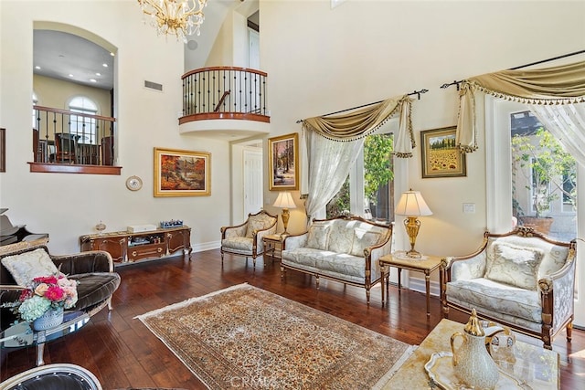 living room with an inviting chandelier, a high ceiling, and dark wood-type flooring