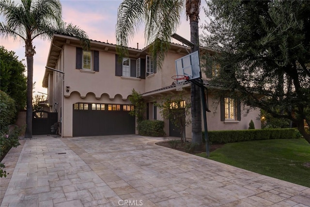 mediterranean / spanish-style house with a lawn and a garage