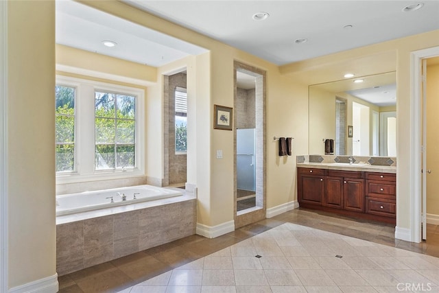 bathroom featuring plus walk in shower, tile patterned floors, and vanity