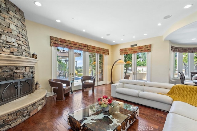 living room with a fireplace, french doors, and dark hardwood / wood-style flooring