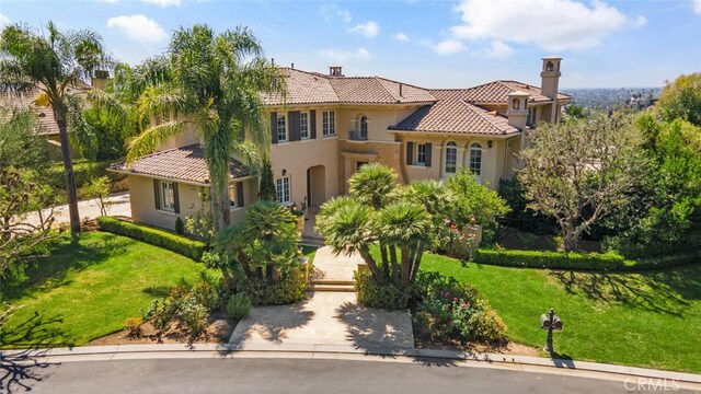 11755 Collar Ave, Tustin, CA 92782 - mediterranean / spanish-style home featuring a tiled roof, a front yard, stucco siding, and a chimney