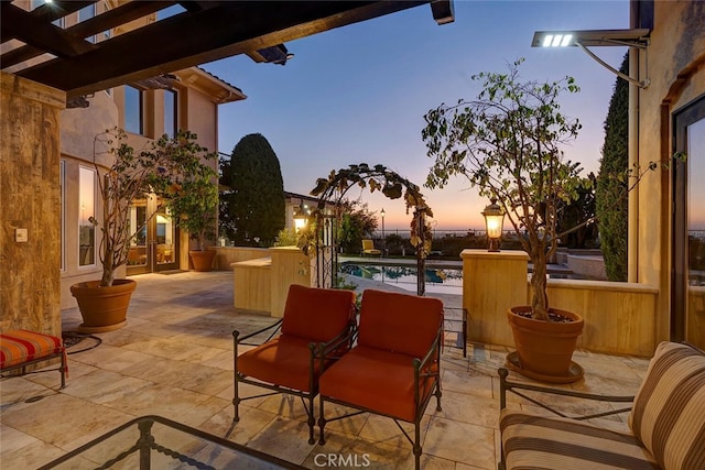 patio terrace at dusk featuring a pergola