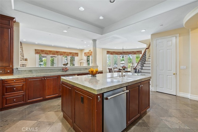 kitchen with dishwasher, a center island with sink, a healthy amount of sunlight, and ornate columns