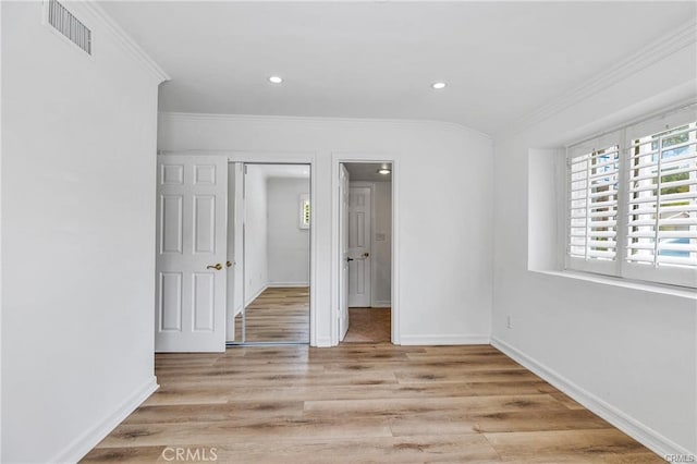 spare room with light hardwood / wood-style floors and crown molding