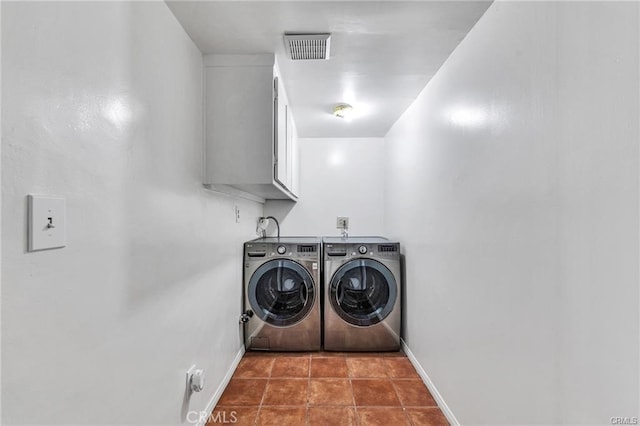 washroom featuring washing machine and dryer, tile patterned flooring, and cabinets