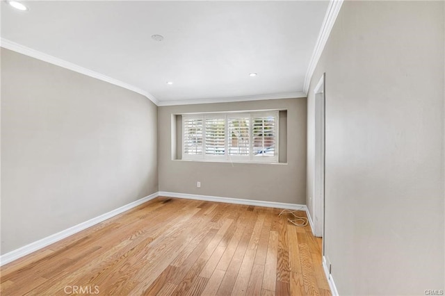 spare room with ornamental molding and light hardwood / wood-style flooring