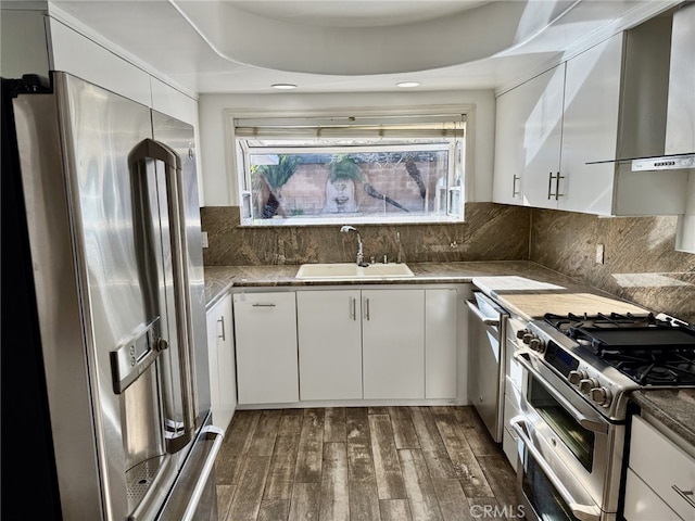 kitchen featuring sink, tasteful backsplash, appliances with stainless steel finishes, dark hardwood / wood-style floors, and white cabinets