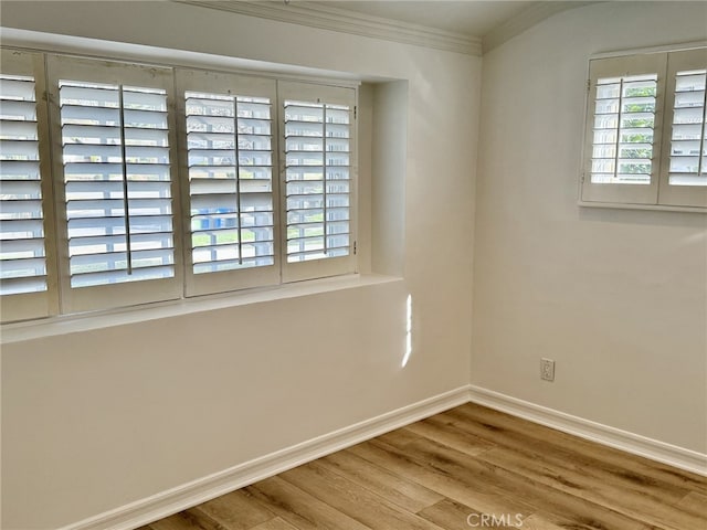 unfurnished room featuring hardwood / wood-style flooring, ornamental molding, and a healthy amount of sunlight