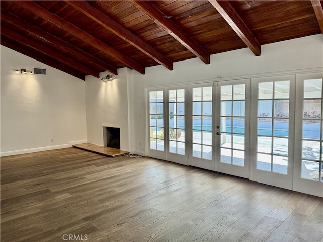 unfurnished living room with hardwood / wood-style flooring, vaulted ceiling with beams, a fireplace, and wood ceiling