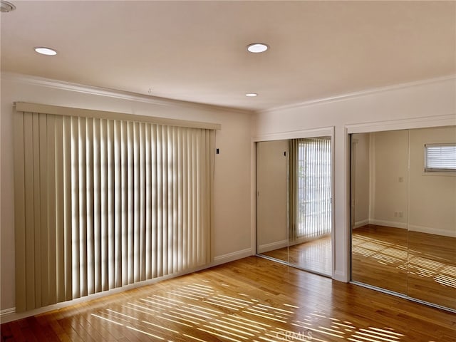 empty room with crown molding and wood-type flooring