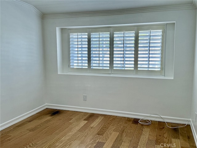 unfurnished room with crown molding, plenty of natural light, and hardwood / wood-style floors