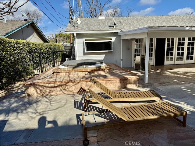 back of house featuring a covered hot tub and a patio area