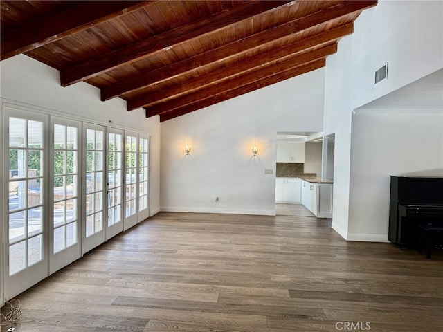 unfurnished living room with beamed ceiling, french doors, light hardwood / wood-style flooring, and wooden ceiling