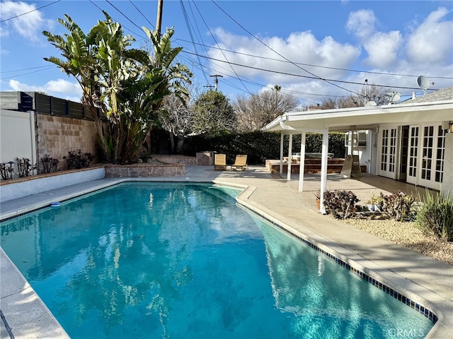 view of pool with french doors and a patio area