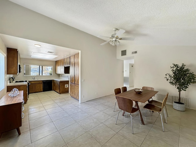 tiled dining area featuring a textured ceiling, ceiling fan, sink, and lofted ceiling