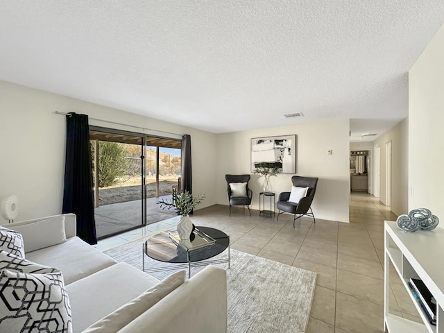 tiled living room featuring a textured ceiling