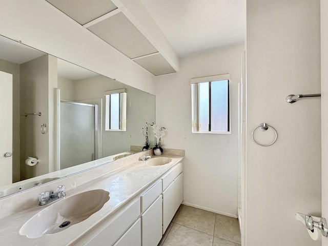 bathroom with tile patterned flooring, vanity, a healthy amount of sunlight, and walk in shower