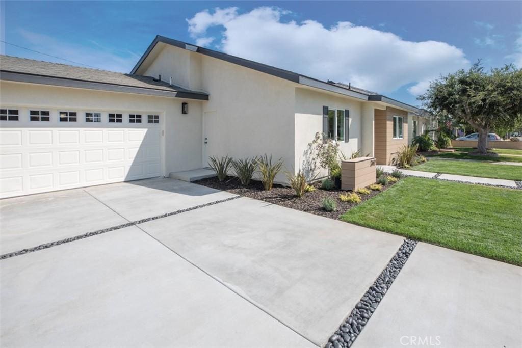 view of front of house featuring a garage and a front lawn