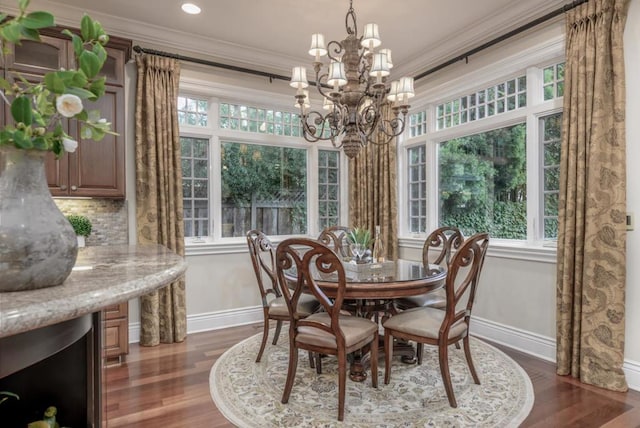 dining space with crown molding, dark hardwood / wood-style floors, a healthy amount of sunlight, and a chandelier