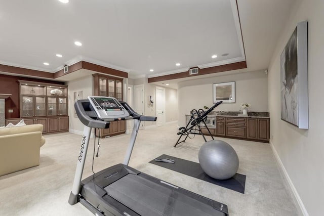 workout area featuring ornamental molding, a fireplace, and light colored carpet