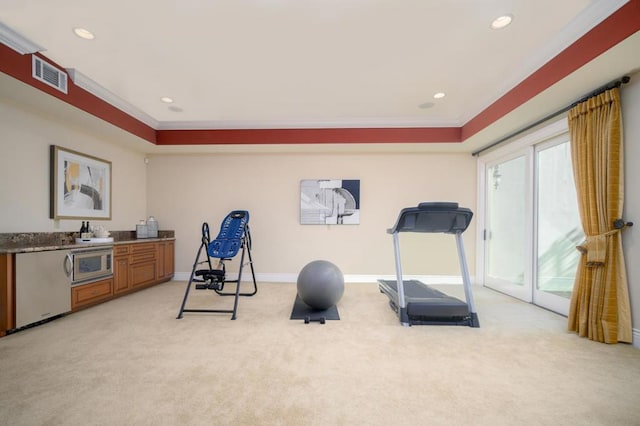 workout room with light carpet, crown molding, and a raised ceiling