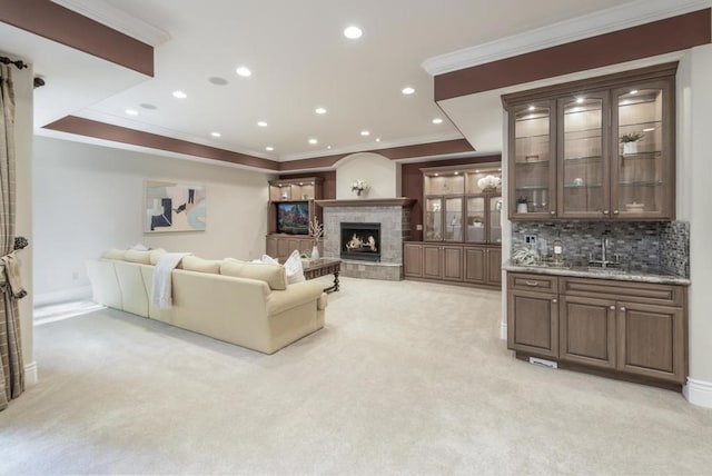 carpeted living room with ornamental molding and wet bar