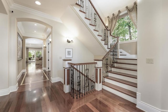 stairs with ornamental molding and hardwood / wood-style floors